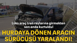 Lüks araç tren raylarına girmekten son anda kurtuldu! Hurdaya dönen aracın sürücüsü yaralandı