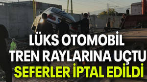 LÜKS OTOMOBİL TREN RAYLARINA UÇTU, SEFERLER İPTAL EDİLDİ